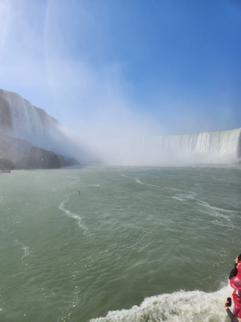 A partial view of the Horseshoe part of Niagara Falls from a boat. The falls are mostly obscured by the mist that comes off of them. 