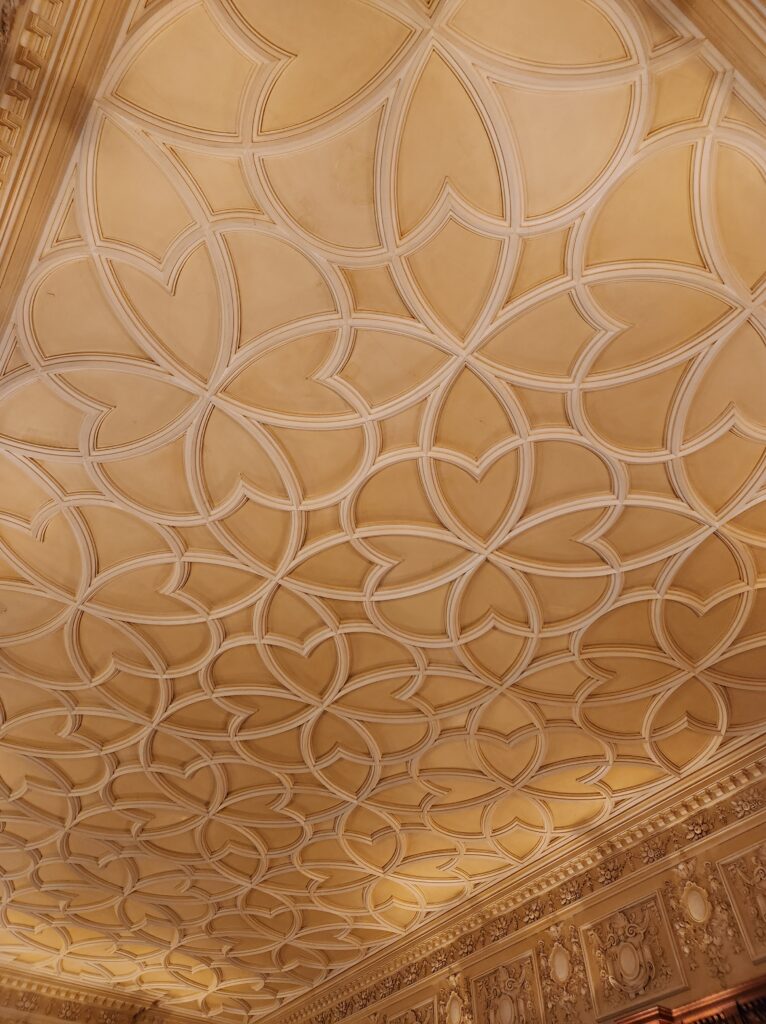 A ceiling decorated with an elaborate design that matches the room below. 